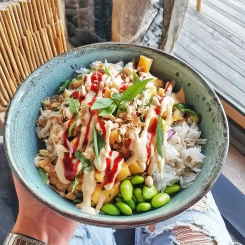 Bol Bouddha avec mangue, edamame et riz au jasmin, un plat végétarien coloré.