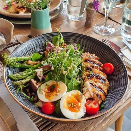 Bowl de poulet grillé avec des asperges et vinaigrette au miso, plat savoureux.