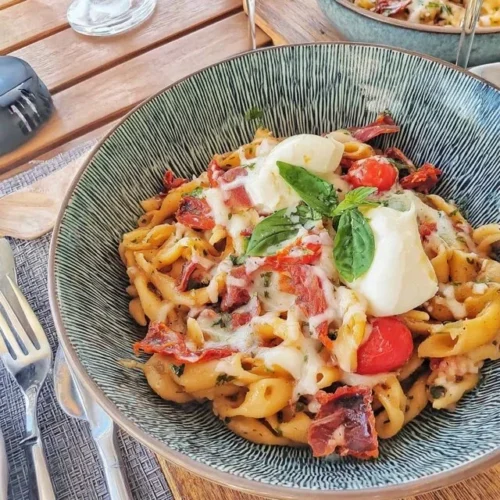 Salade de pâtes aux tomates séchées et mozzarella dans un bol.