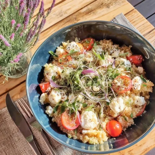 Salade de quinoa avec petits pois, feta et menthe, servie dans un bol coloré.