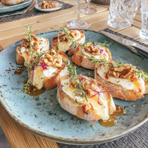 Tartines apéro avec chèvre, miel et noix sur une planche en bois
